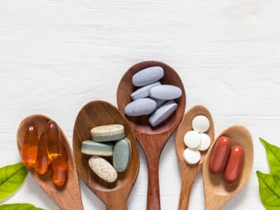 Image of supplements for leaky gut in spoons on a white background.