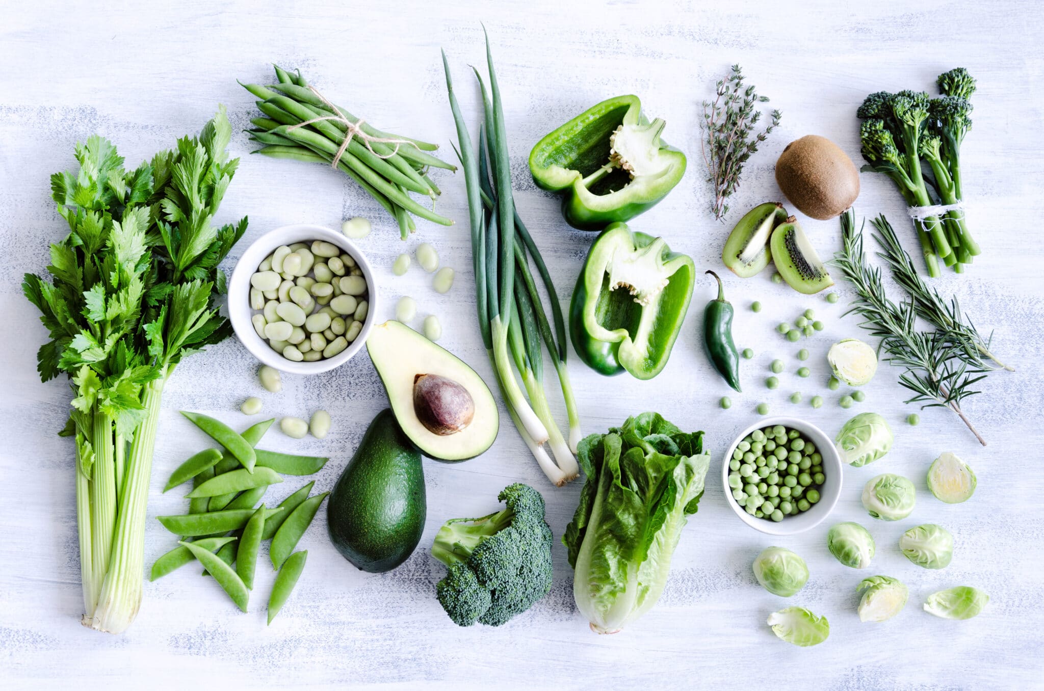 Green vegetables on a white cutting board