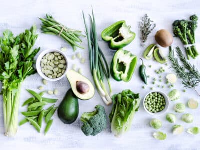 Green vegetables on a white cutting board