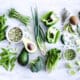 Green vegetables on a white cutting board