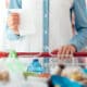 Woman doing grocery shopping at the supermarket, she is pushing a cart and checking a list