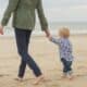 Woman walking towards the ocean with her son