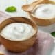 Homemade yogurt in a wooden bowl with a wooden spoon and napkin.