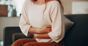 woman experiencing digestive discomfort takes an at home stool testing kit to find the root problem